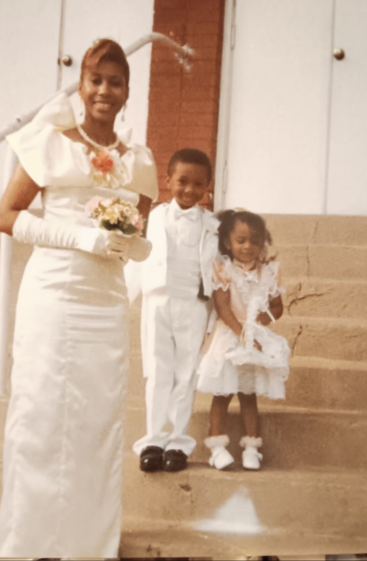 Mary Kingcannon in her wedding gown on the church steps with her young son and daughter