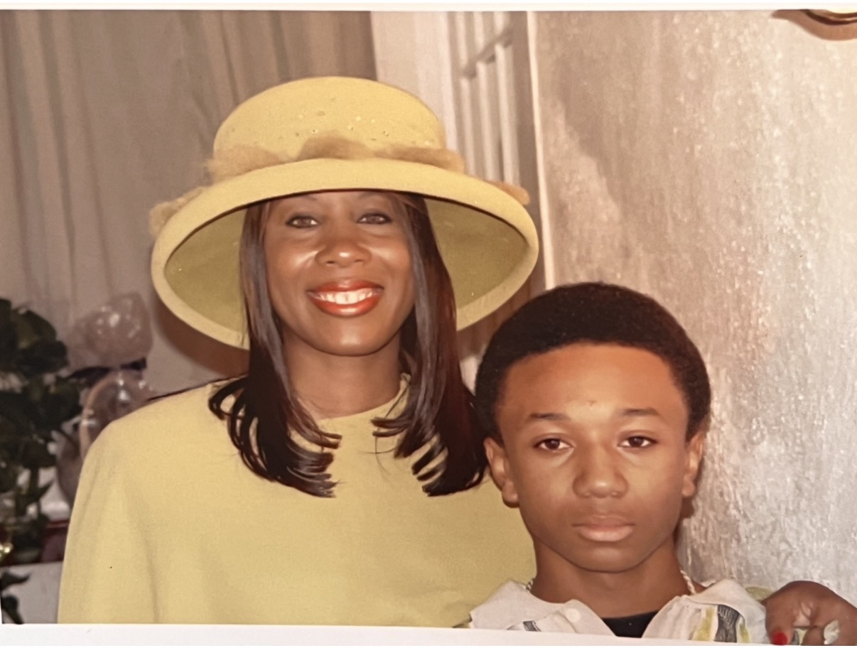 Mary in a soft yellow hat and dress with her young son