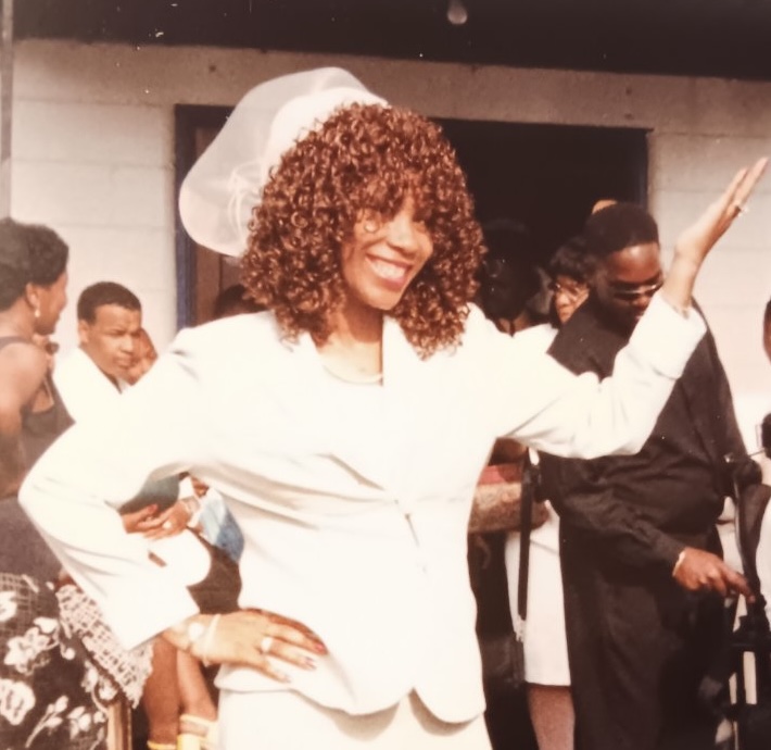 A young Mary Kingcannon praising in a white suit and white hat